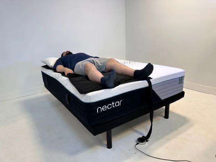 A man lies on his back on a pressure-sensitive mat on the Nectar Premier mattress