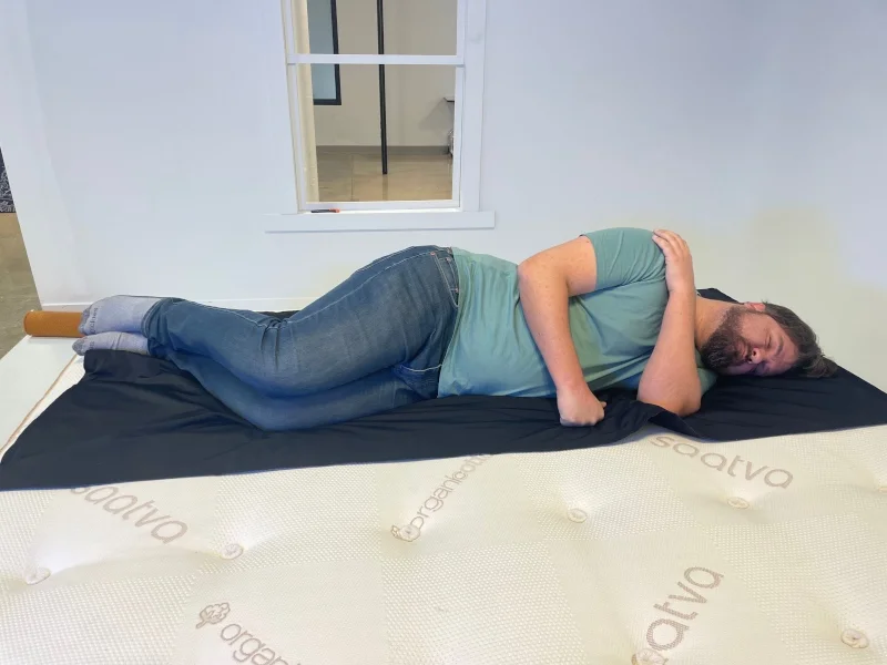 A person side-sleeping on a pressure mat on a Saatva Latex Hybrid mattress.
