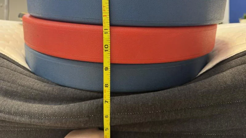 Measuring the deflection of weight plates along the edge of the Brooklyn Bedding Plank Firm Luxe Mattress