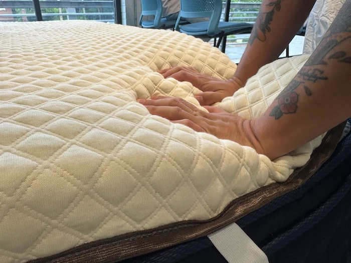 Our tester pressing down on the Naolah Mattress Topper to assess supportiveness