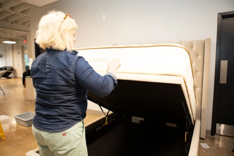 Sosha Lewis lifts the mattress on a Saatva Amalfi Storage Bed