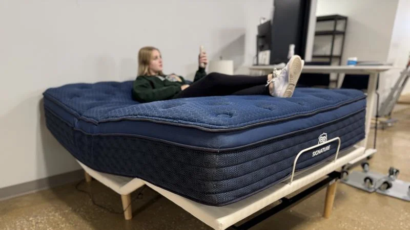 Our tester assessing a Brooklyn Bedding Signature Hybrid Mattress on an adjustable bed.
