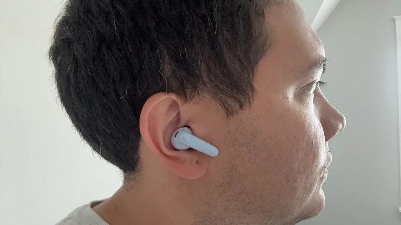 Our tester with a pair of Anker Soundcore P31i earbuds