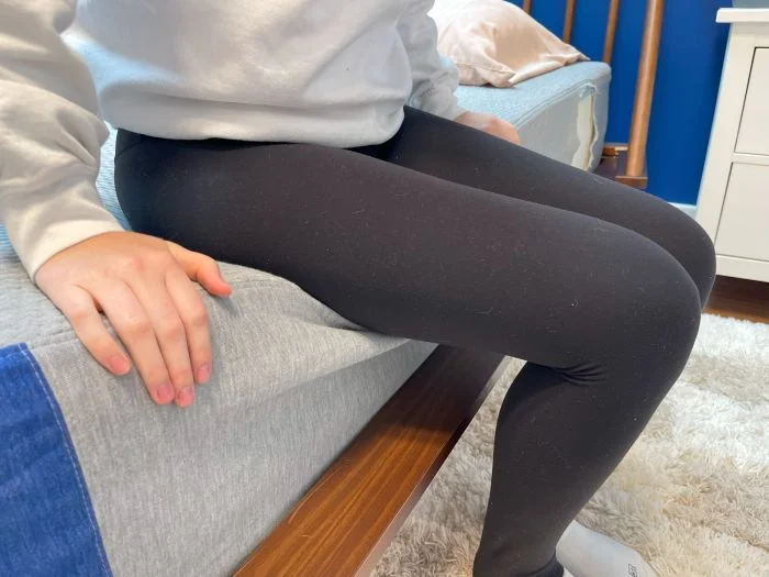 A woman sitting on the edge of the Casper The One mattress.