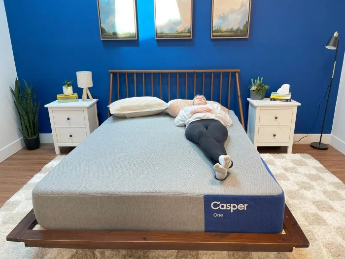 A woman lying on her back on The Casper The One mattress.