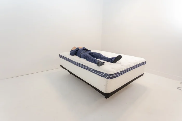 A man lying on his back on the WinkBed Plus mattress.