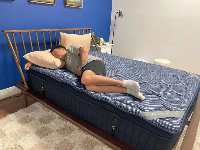 A man sleeps on his side on the Dreamcloud Luxe Hybrid