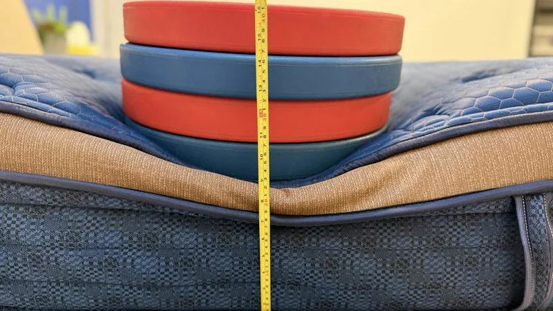 Our tester measures the deflection of weight plates along the edge of the Brooklyn Bedding Aurora Luxe mattress