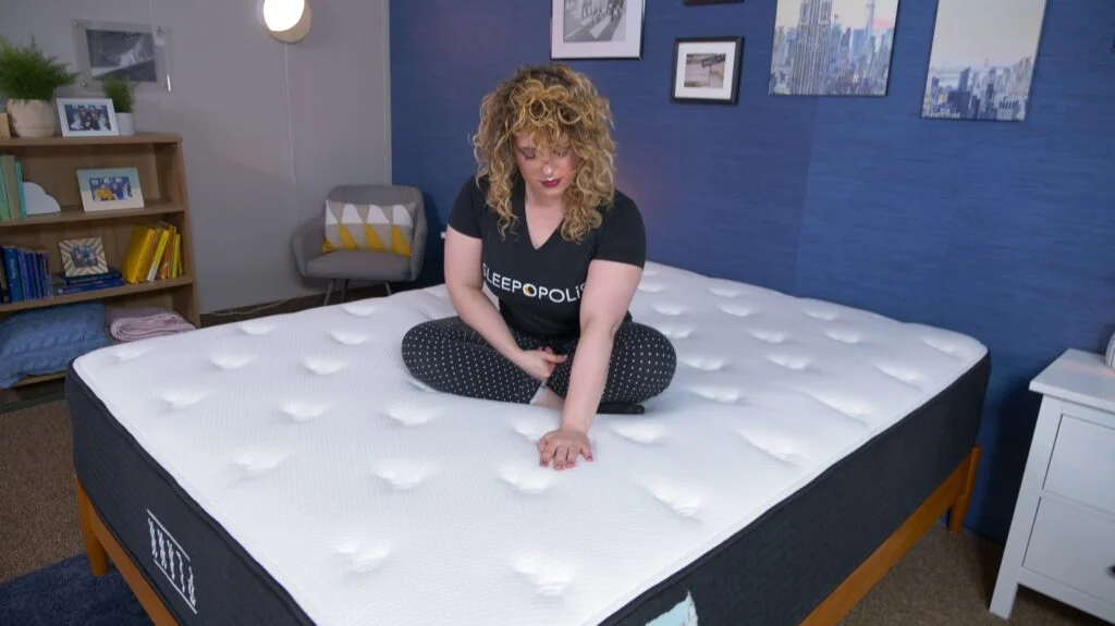 Nichole feeling the cover of the extra-firm side on the Plank Firm Luxe Construction