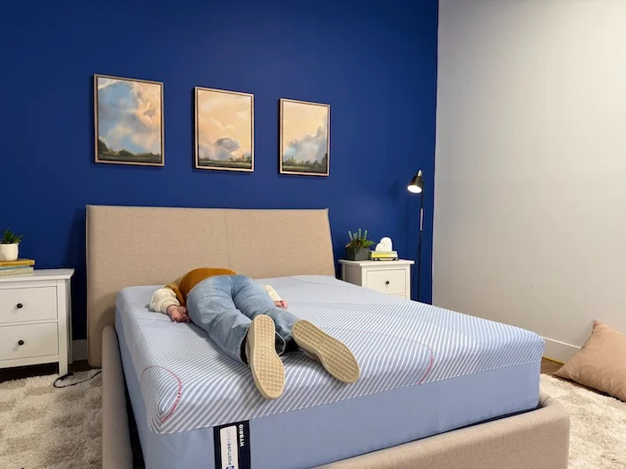 A woman lying on her stomach on the Sealy Posturepedic mattress.