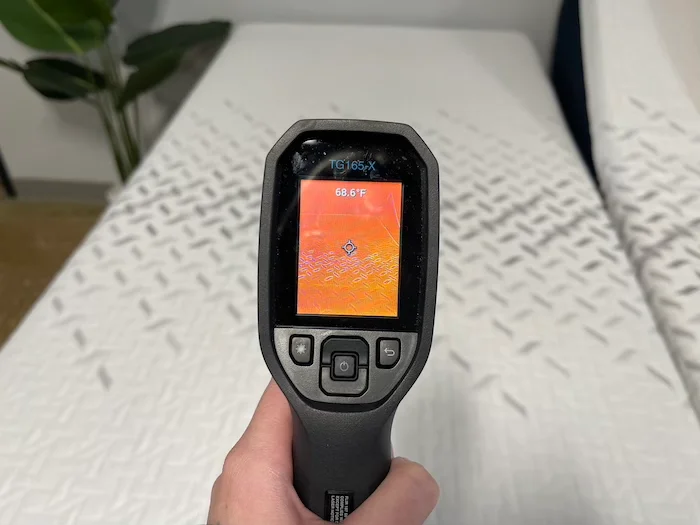 A closeup of a thermal gun reading the temperature of the Nectar Premier mattress at a neutral temperature. The screen reads 68.6 degrees.