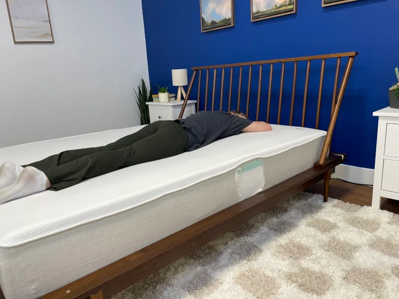 Our tester stomach-sleeping on a Boring Hybrid Mattress