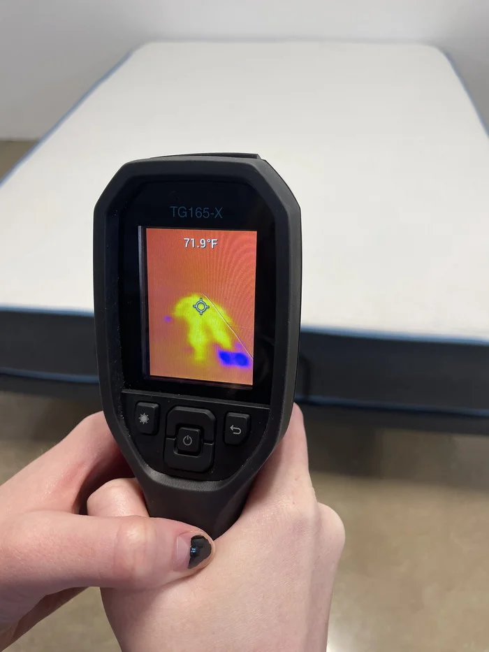 A closeup of someone reading the Bear Original's temperature with a thermal gun after 5 minutes of someone resting on it. The screen reads 71.9 degrees.