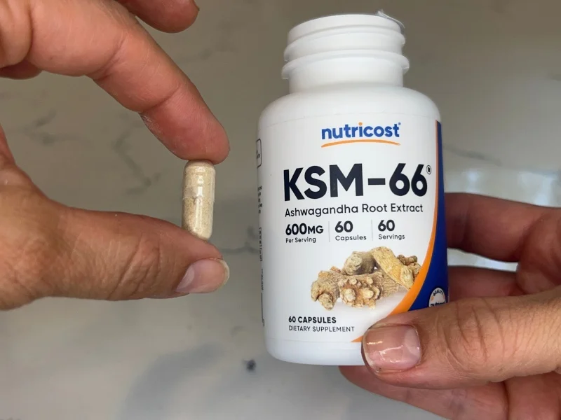Our tester holds up a capsule from a bottle of Nutricost KSM-66 Ashwaganda Extract.