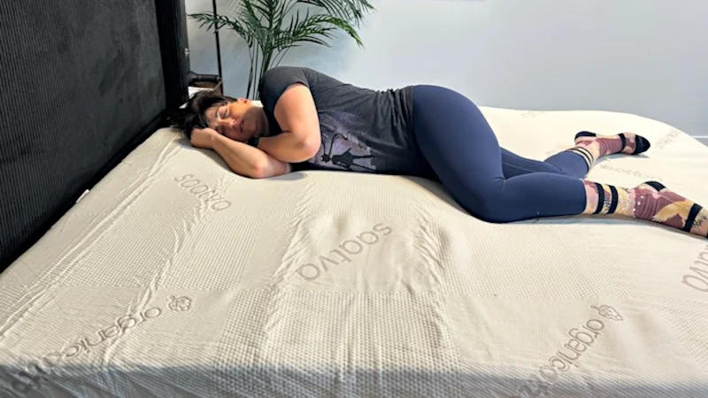 A person laying on Saatva Graphite Topper