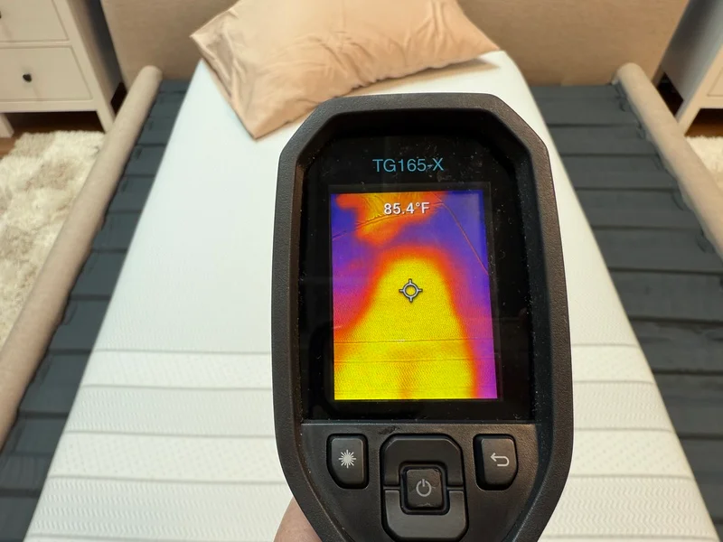 A tester uses a thermal gun to measure the surface temperature of the Leesa Kids mattress.