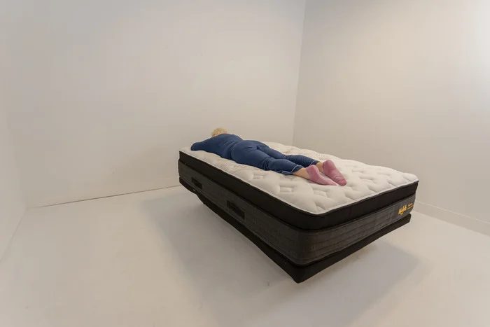 A woman lying on the Nolah Evolution in the stomach-sleeping position.