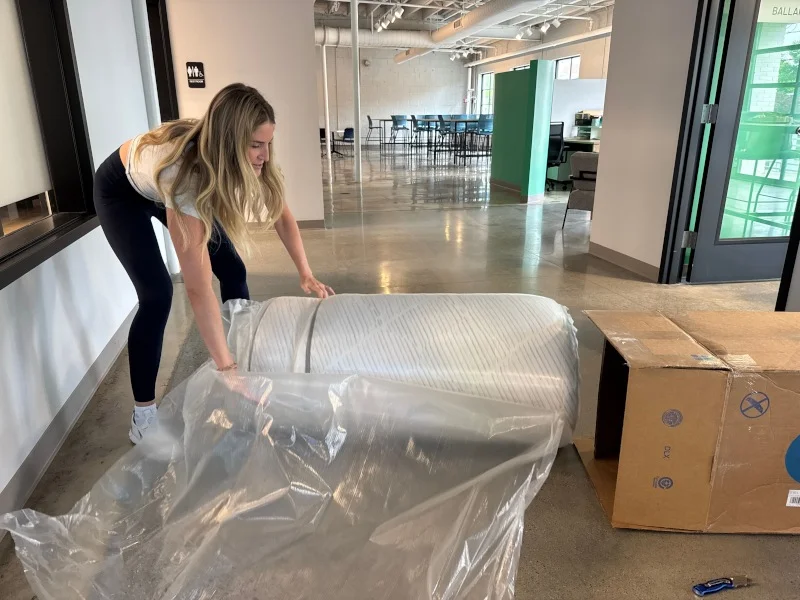 A person unboxing a DLX Classic mattress.