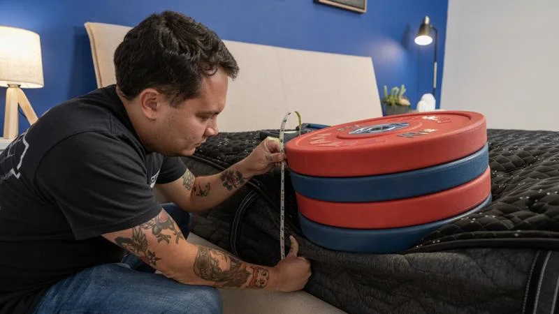 Our tester measures the sinkage from weight plates along the edge of the Beautyrest Black Mattress