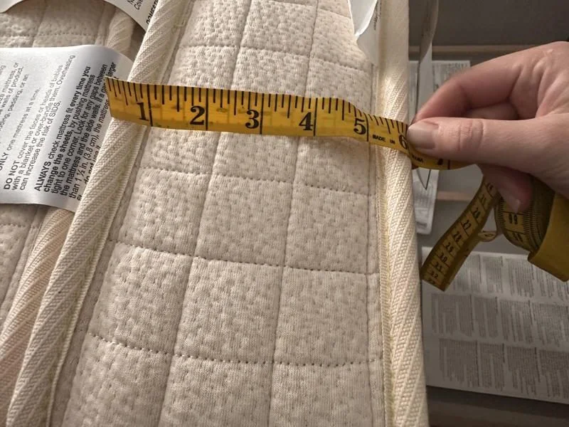 Measuring the thickness of an Avocado Luxury Crib Mattress