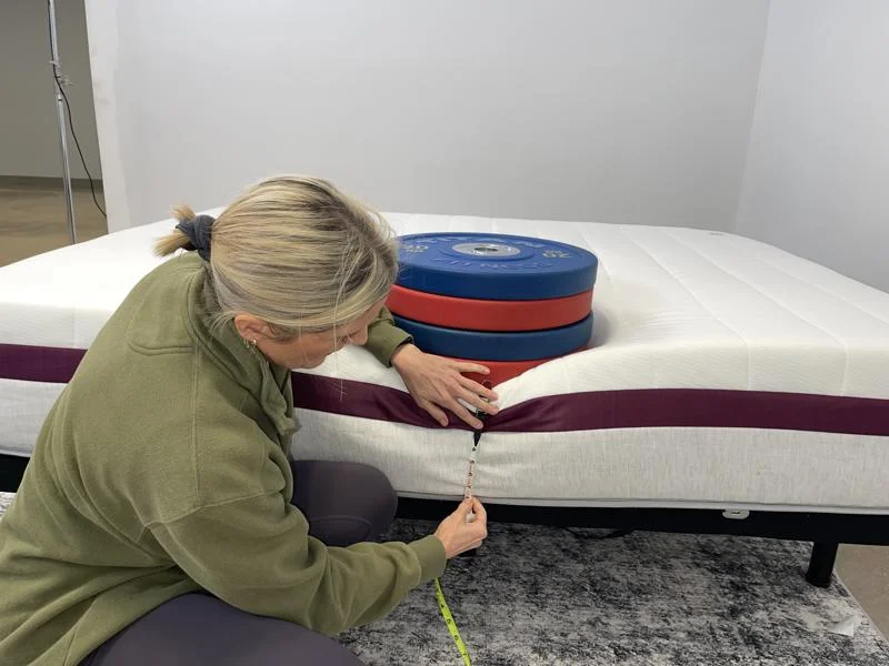 Measuring weight plates on the edge of the Helix Dusk Mattress