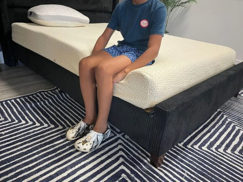 Our tester performs a seated edge support test on the 5 Little Monkeys Memory Foam Mattress