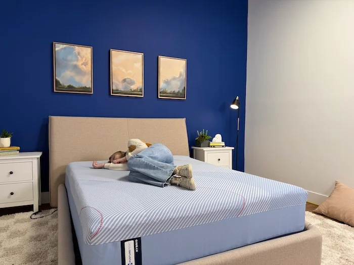 A woman lying on her side on the Sealy Posturepedic mattress.