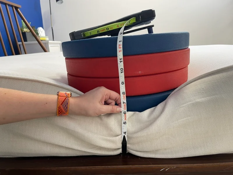 Our tester measures the deflection of weight plates along the edge of a Boring Hybrid Mattress.