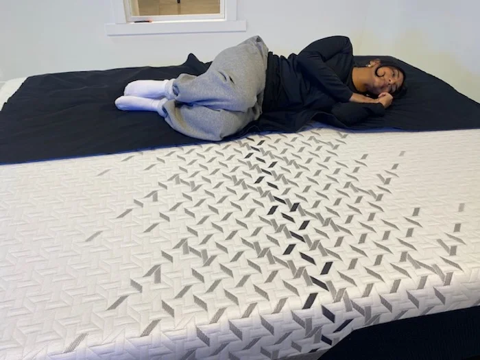 A woman lying on her side on the Nectar Luxe Memory Foam.