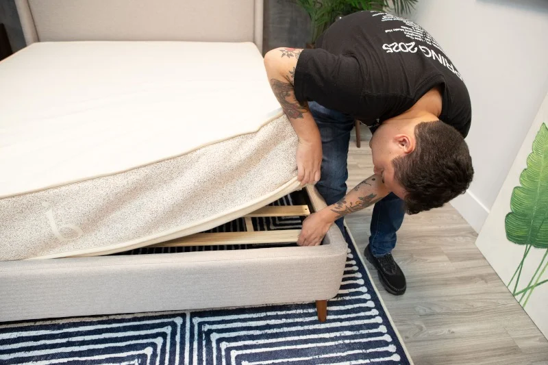 Sleep expert Kenny Timper examines the slats on a Silk & Snow Bed Frame with Storage
