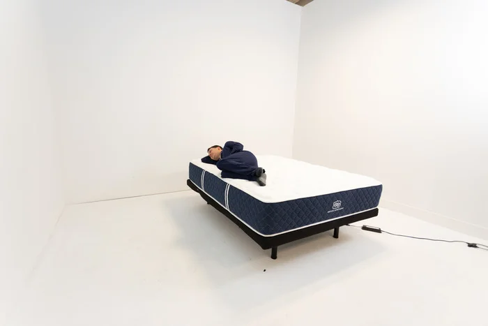 A man lying on the Brooklyn Bedding Signature Hybrid mattress in the side-sleeping position.