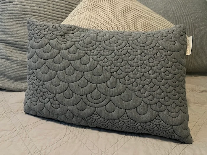 A Brentwood Home Crystal Cove Mini Pillow resting on a bed.