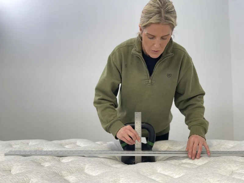 Our tester assessing the sinkage of the Helix Sunset Luxe Mattress