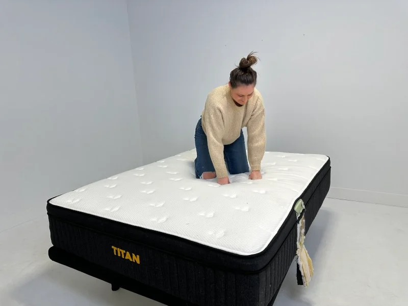 Our tester testing the noise level of a Titan Plus Luxe mattress