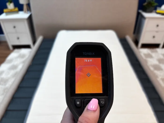 A closeup of a thermal gun reading the Birch Kids mattress's temperature. The screen displays 75.6 degrees.