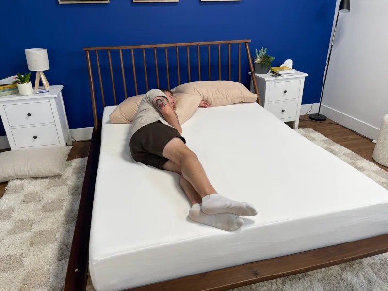 Our tester side-sleeping on the PolySleep Sierra Mattress