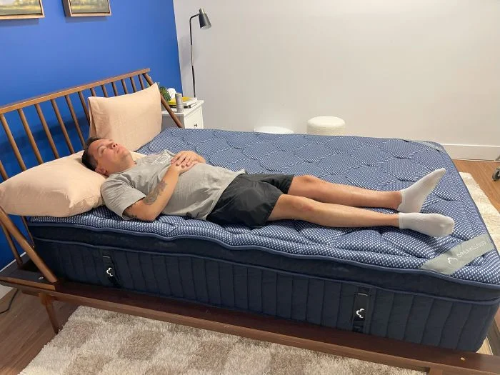 A man sleeps on his back on the Dreamcloud Luxe Hybrid