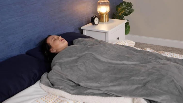woman sleeping under weighted blanket