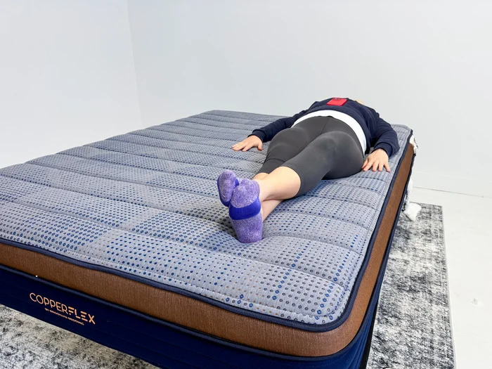A person is shown back-sleeping on a Brooklyn Bedding CopperFlex Mattress