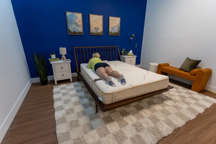 A woman lies on her stomach on the Zenhaven mattress