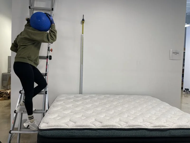 Our tester performs a bounce test on the Helix Sunset Luxe Mattress