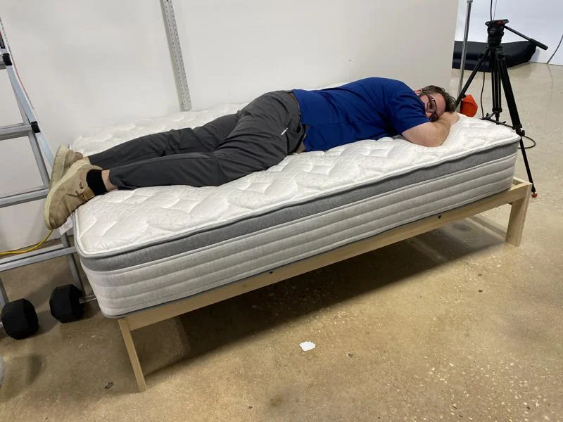 Our tester stomach-sleeping on the Helix Plus Mattress