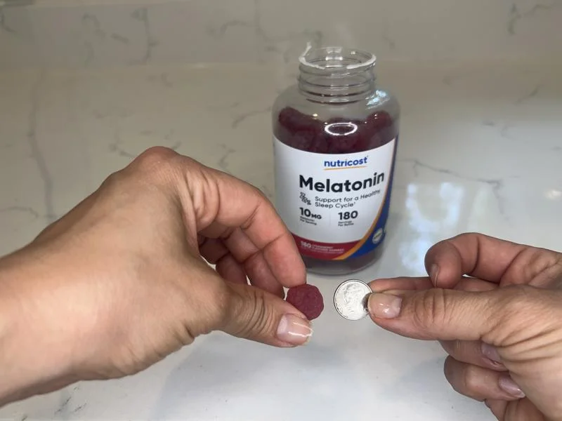 Comparing the size of a Nutricost Melatonin Gummy with a dime