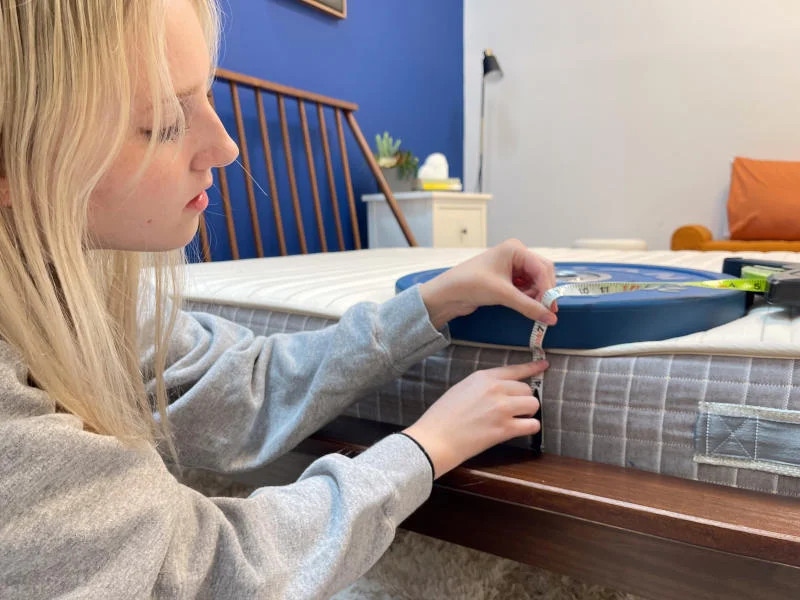 Measuring weight plates on the edge of a Brentwood Homes Juniper Mattress