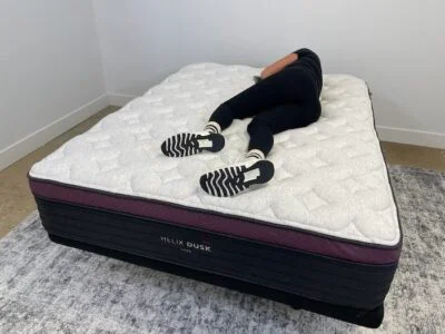 A woman lying on the Helix Dusk Luxe and rolling over to her side.