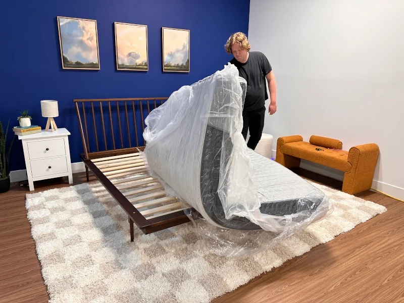 Our tester unfurls a brand new Helix Midnight Luxe Mattress