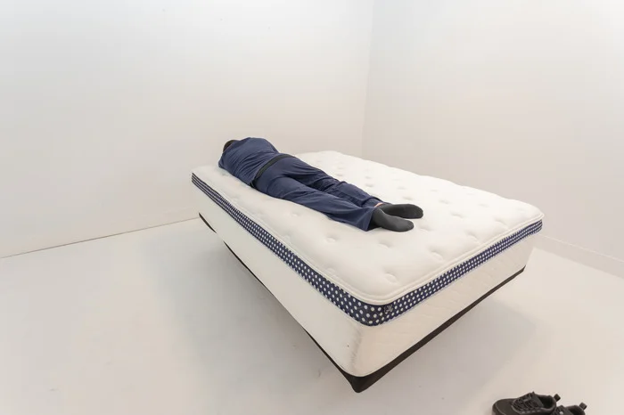 A man lying on the WinkBed Plus in the stomach-sleeping position.