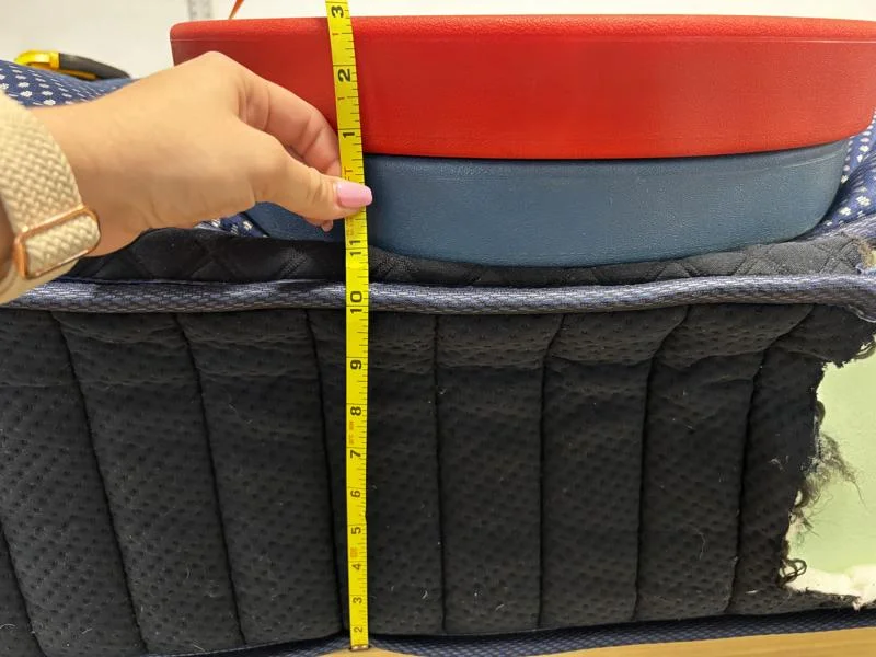 Measuring weight plates on the edge of a DreamCloud Luxe Memory Foam Mattress