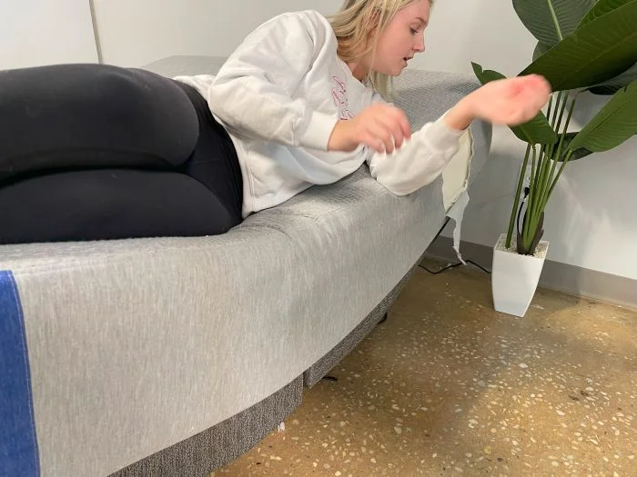 A woman lying on a Casper The One mattress that's resting on top of an adjustable base.