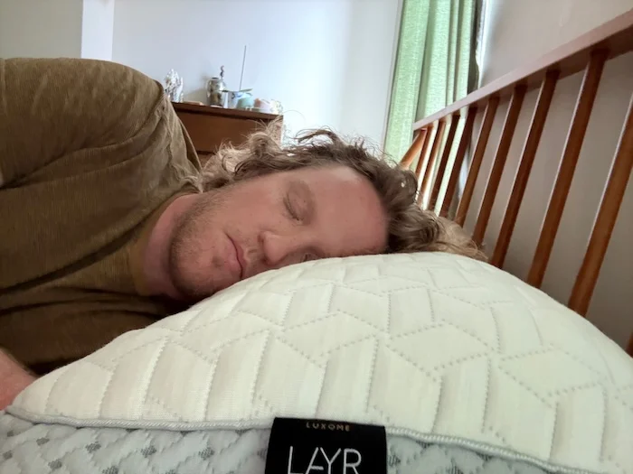 A man side sleeping on the Luxome LAYR pillow.
